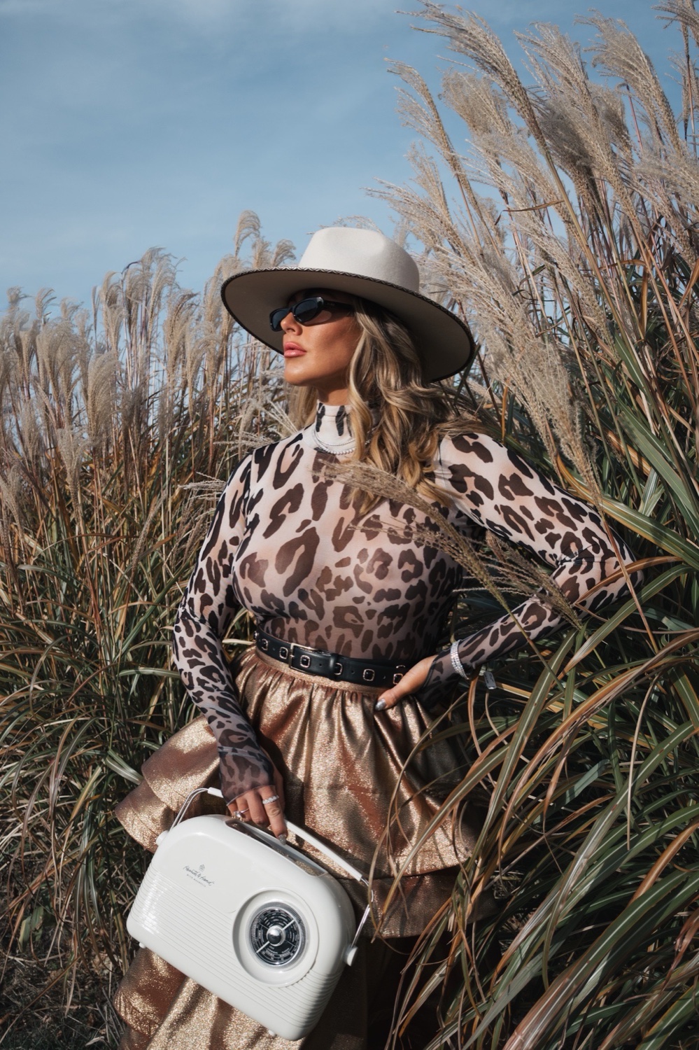 Ashleigh Malangone in leopard and gold in a field of pampas grass