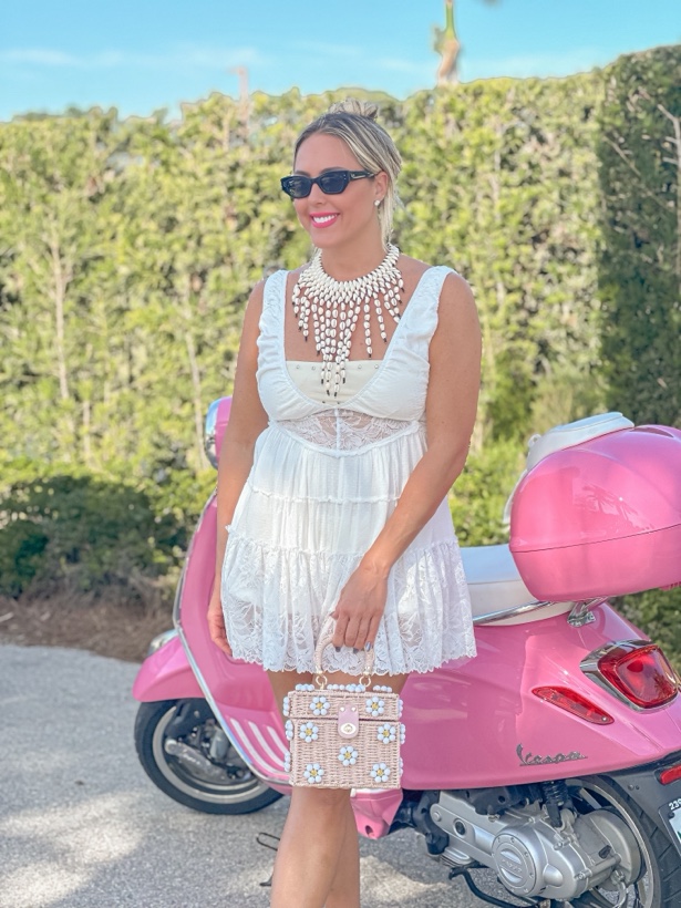 Ashleigh Malangone in a white dress beside a pink scooter