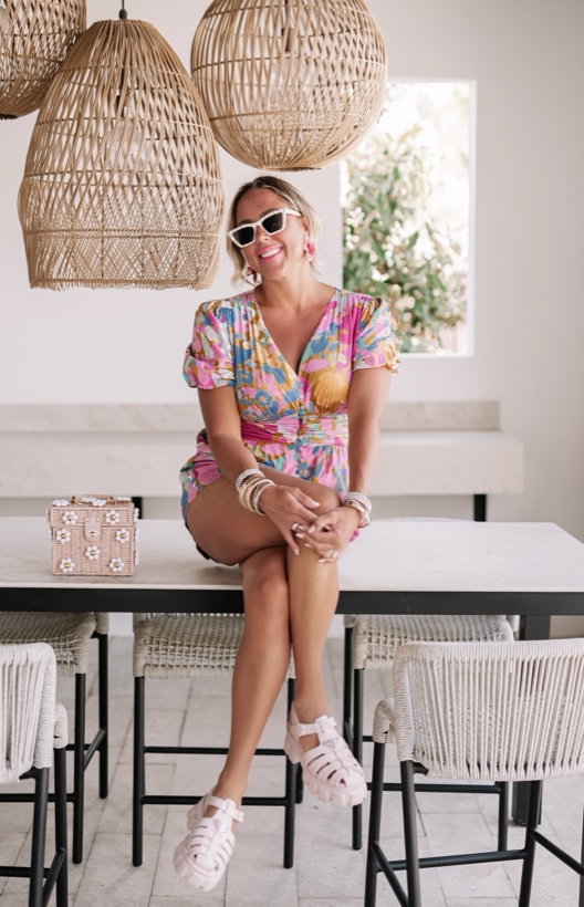 Ashleigh Malangone in a floral outfit under rattan pendant lights