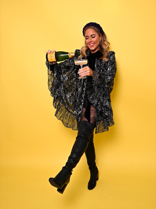 Ashleigh Malangone pouring champagne on a yellow backdrop